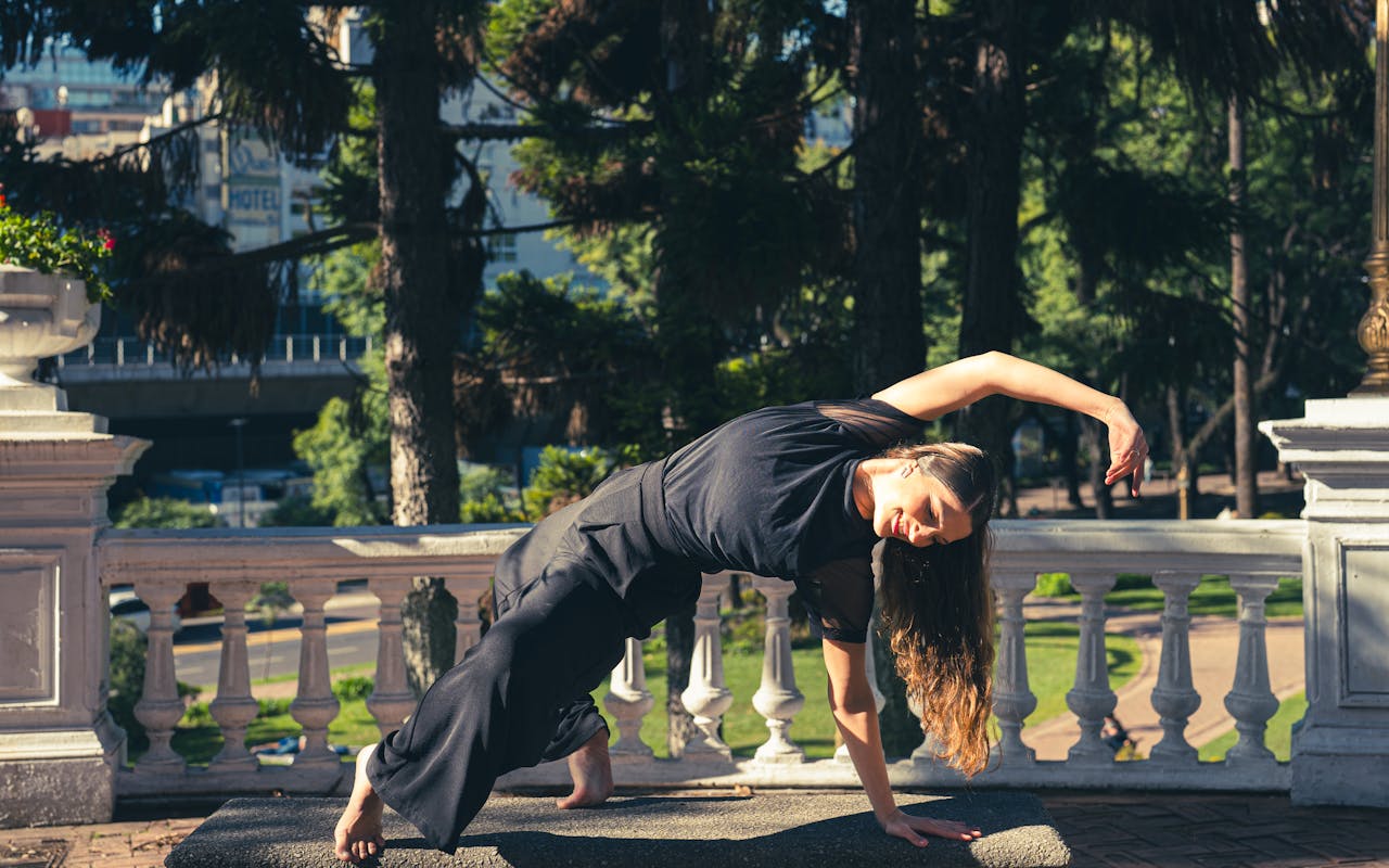 Woman practicing yoga outdoors in a Buenos Aires park on a sunny day.